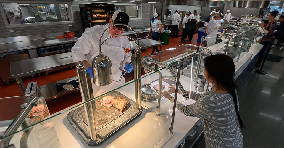 student watches on as food is prepared for her in uc davis dining commons