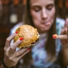 Girl eating a cheeseburger at a fast food restaurant