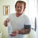 Matthew Trevi帽o holds a canister of a hormonal birth control gel for men while in his home in Sacramento. He is part of a clinical trial at 春色视频 Health testing the new drug. 