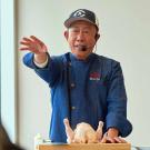 Martin Yan gestures during a cooking demo
